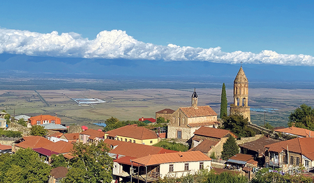 Von der Stadtmauer ­Sighnaghi aus öffnet sich der Blick auf die Berge des großen Kaukasus. Herrliche Landschaften, orthodoxe Kirchen, Kultur- und Kulinarikschätze bietet Georgien, das Ziel der nächsten Leser:innenreise.