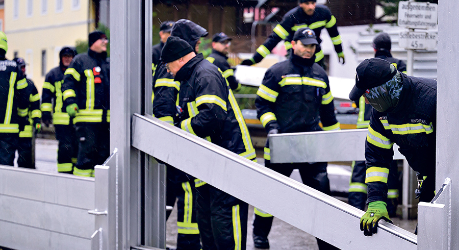 Feuerwehrleute errichten den Hochwasserschutz in Mauthausen.  