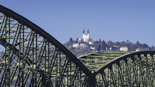 Urlaub in der Stadt. Dieses Bild von der Pöstlingbergskirche entstand, als die Eisenbahnbrücke noch über die Donau führte. 