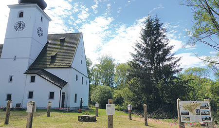 Zettwinger Kirche mit den Stelen des zeitgeschichtlichen Informationskreises 