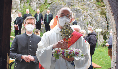 Begleitet von Pfarrer Martin Brons aus Nürnberg (links) bringt Diakon Martin Rögner die Reliquie in die Kirche.  