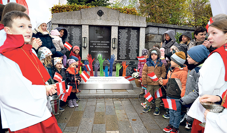 Eine Kinderschar vor dem neu errichteten, bunten Friedensdenkmal.    / Stonig Eine Kinderschar vor dem neu errichteten, bunten Friedensdenkmal.