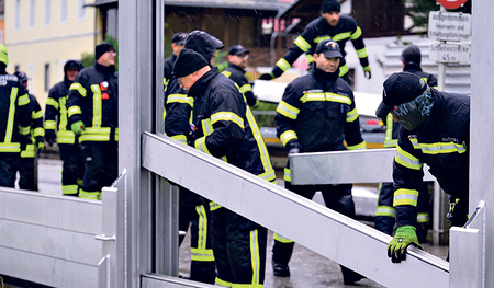 Feuerwehrleute errichten den Hochwasserschutz in Mauthausen.  