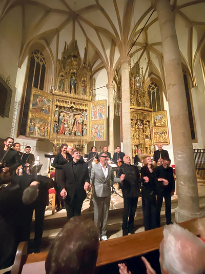 Die Musiker: innen und die DKV-Reisegruppe unter der Leitung von Maria Reitter-Kollmann bei der Uraufführung des Werks „Benedicte domino“ von Peter WesenAuer in Hallstatt.