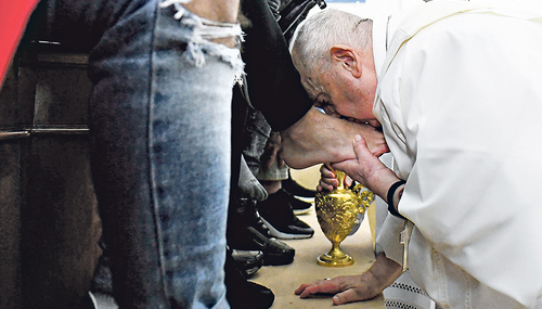 Papst Franziskus küsst einem jugendlichen Straftäter die Füße bei der Fußwaschung am Gründonnerstag.  